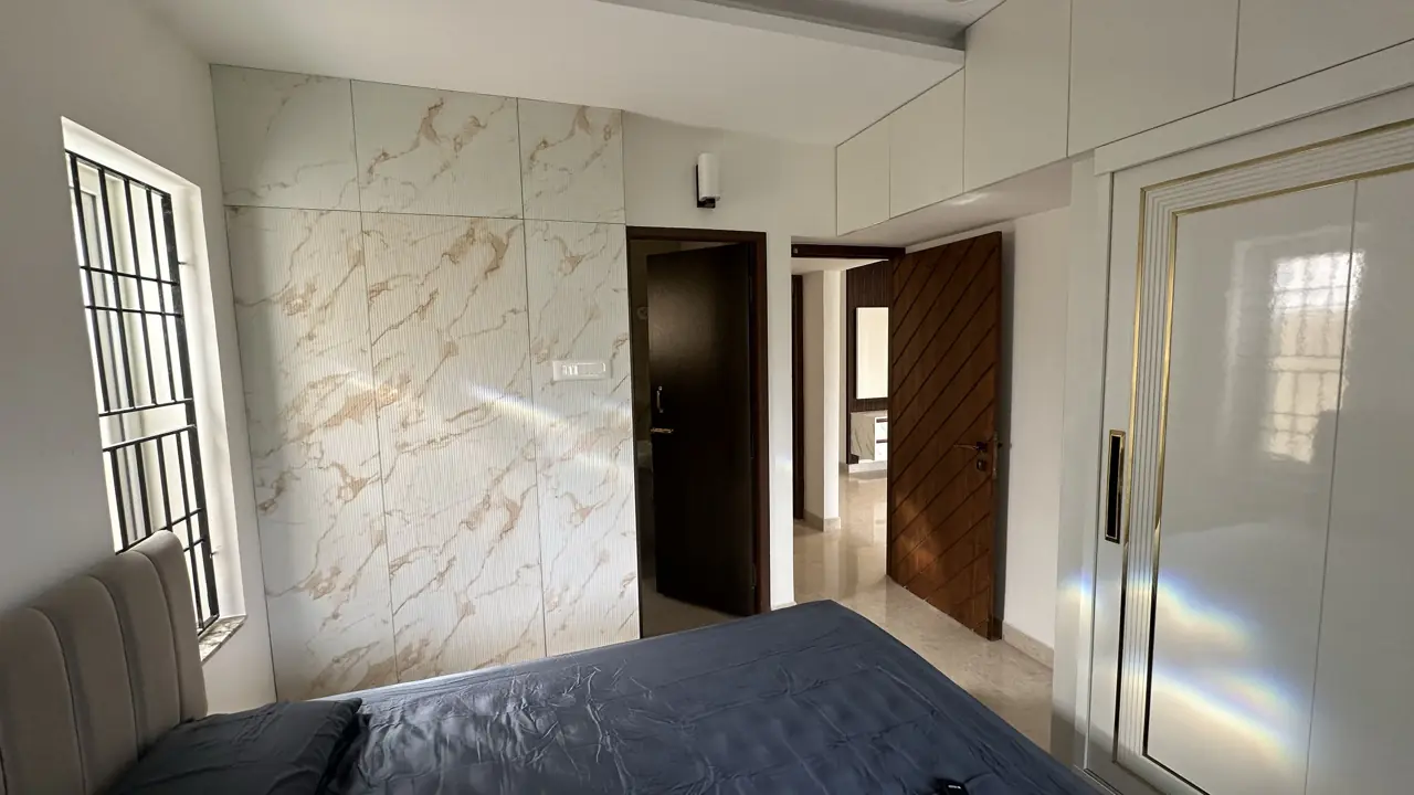 Bedroom with marble-effect feature wall and lacquered wardrobe