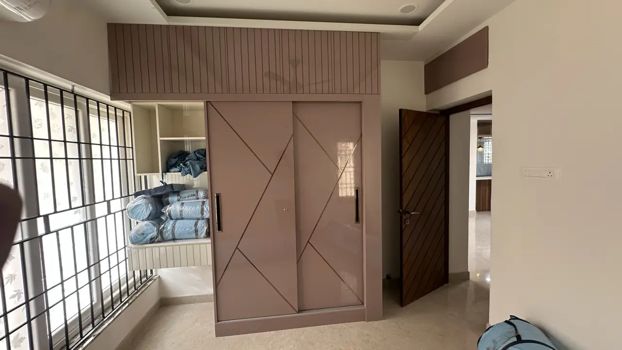 High-gloss sliding wardrobe with geometric groove pattern and loft storage